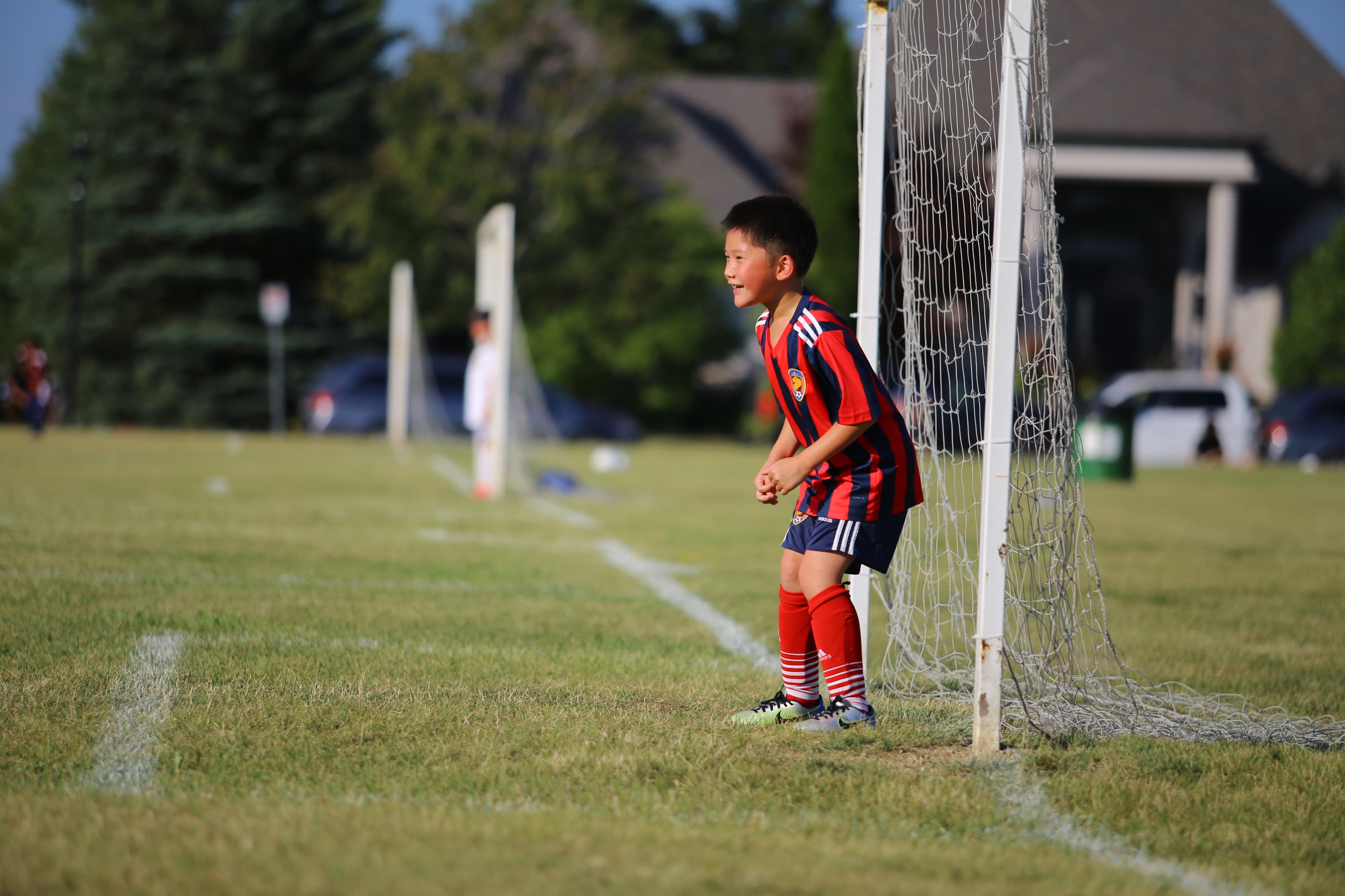 A young soccer player cheering on their team from the sideline